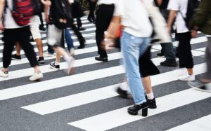 multiple people's legs as they walk on a crosswalk