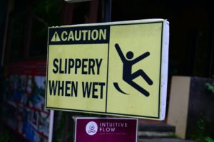 yellow sign that says "caution slippery when wet"
