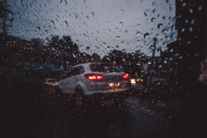 rear of car through a windshield while raining