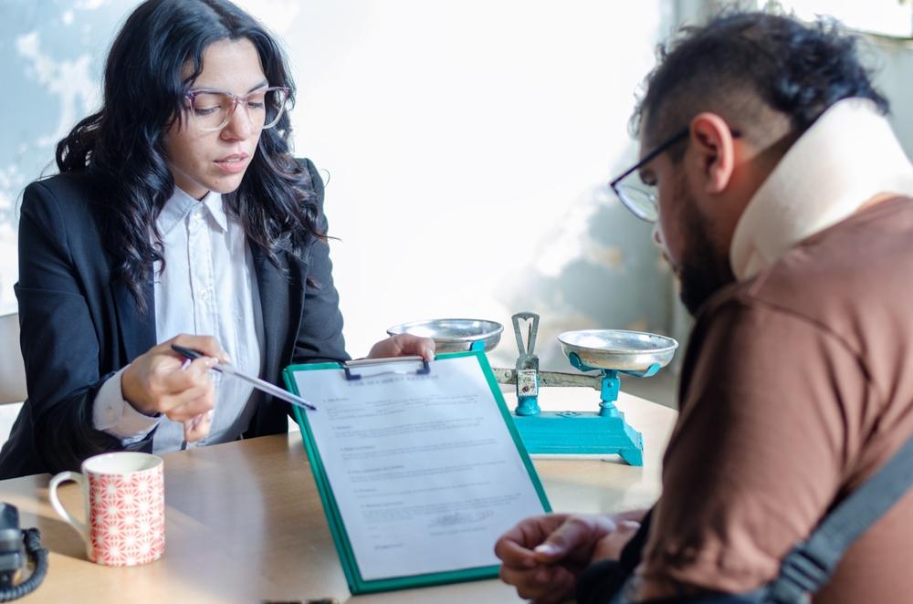 Young lawyer showing a document paper to a male client., insurance, legal contract or lawyer consulting.