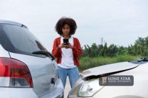 Half Thai African driver check for damage after a car accident before taking pictures and sending insurance.
