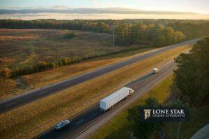View from above of busy american highway with fast moving trucks and cars. Interstate transportation concept